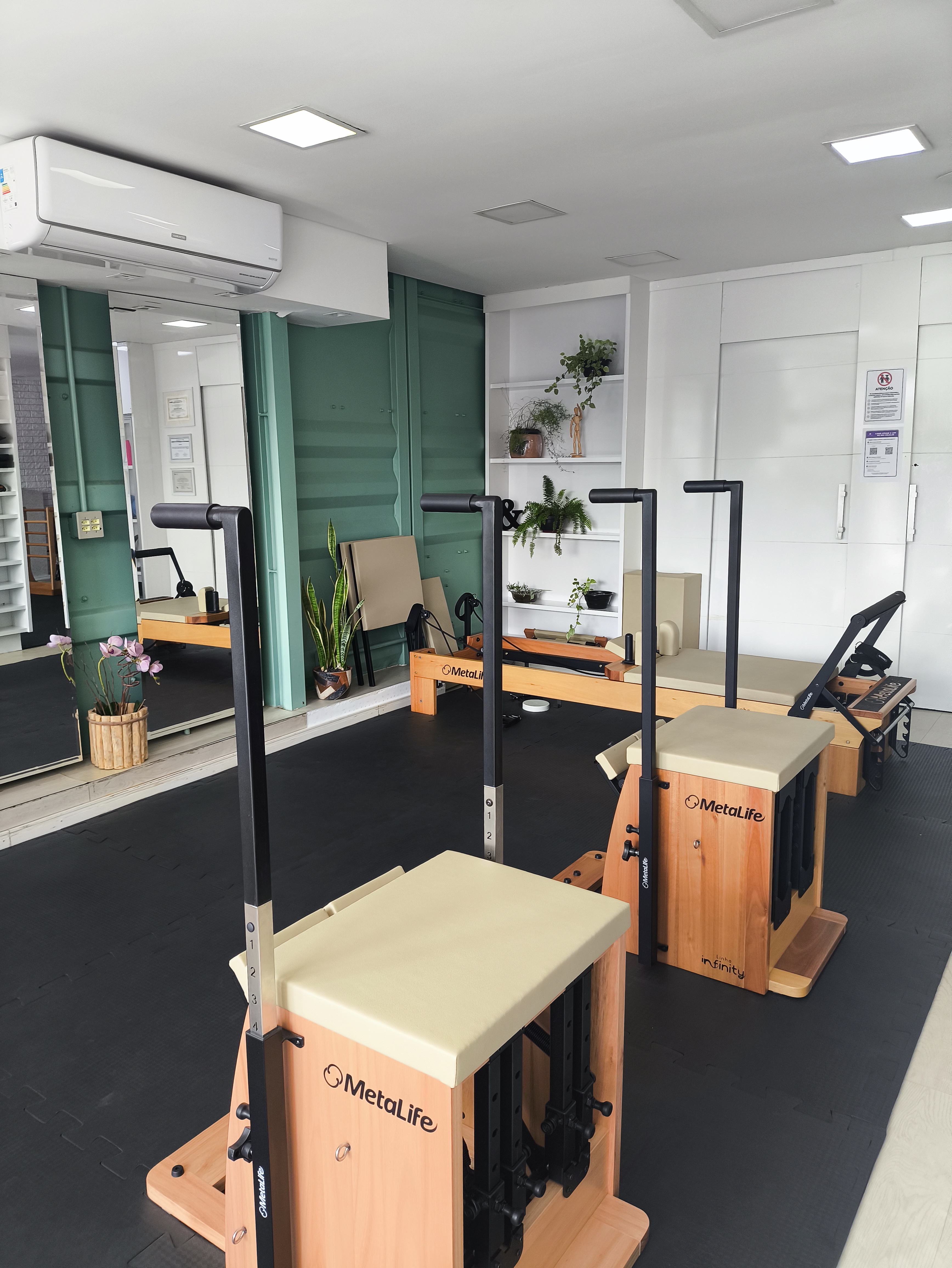 Sala de pilates clínico do Vitta Sul Pilates com cadeiras e espelhos